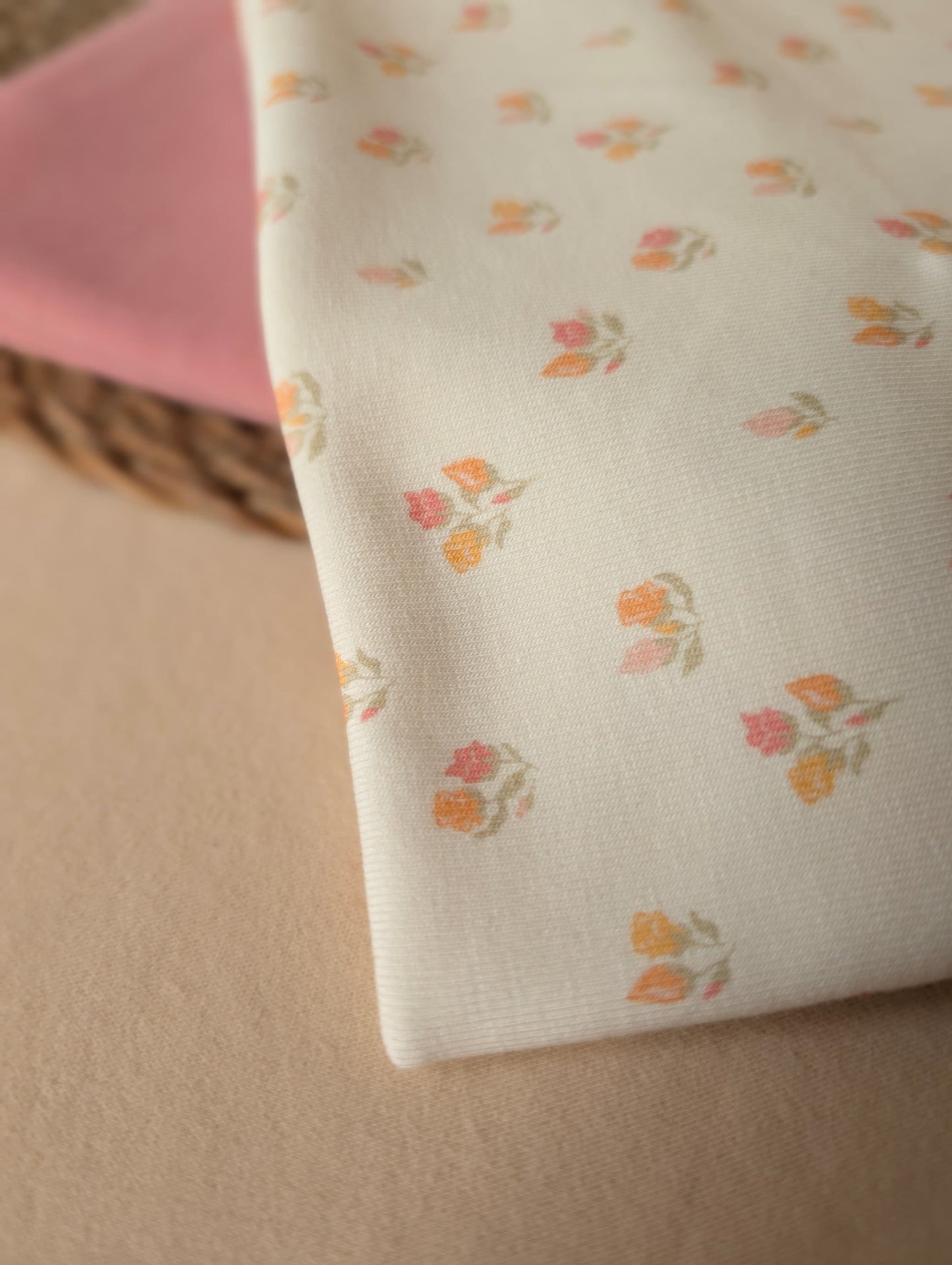 Beatrice Floral Cotton Rib Pastel folded on wicker mat — angled view of floral print in soft pastel tones on textured cotton rib — Esorai