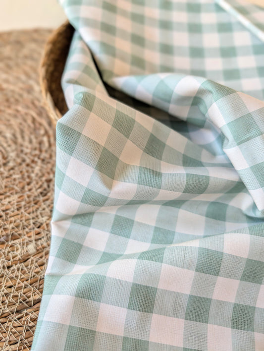 Celeste Sage Gingham Check Cotton — sage green and white gingham fabric draped over a wicker basket