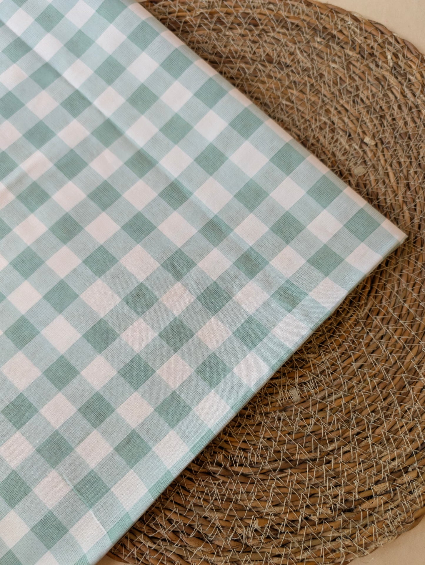 Celeste Sage Gingham Check Cotton — sage green and white gingham fabric draped over a wicker basket