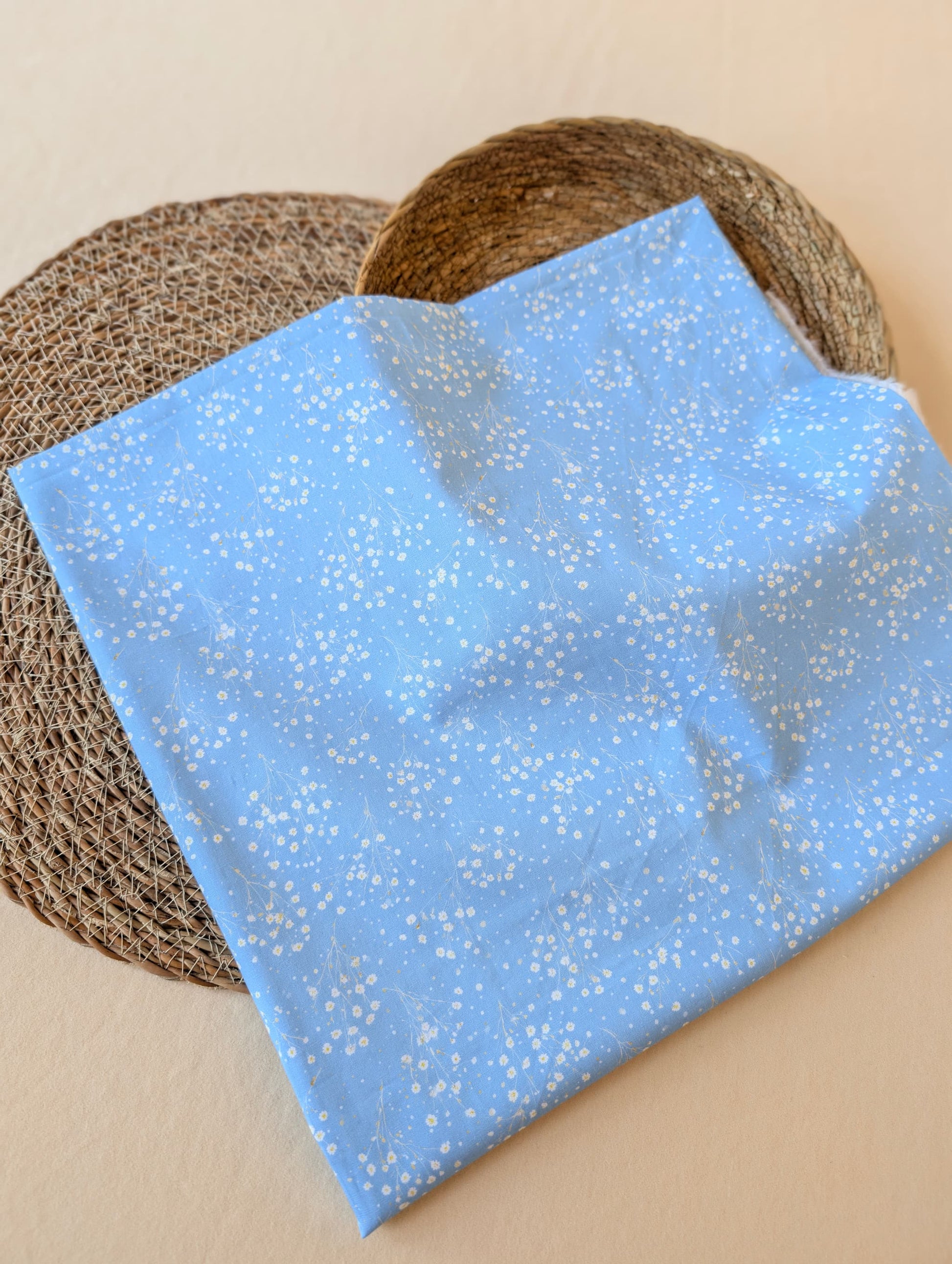 Clara Daisy Floral Cotton Poplin by esorai — scattered white daisy print on cornflower blue ground, fabric draped in wicker basket