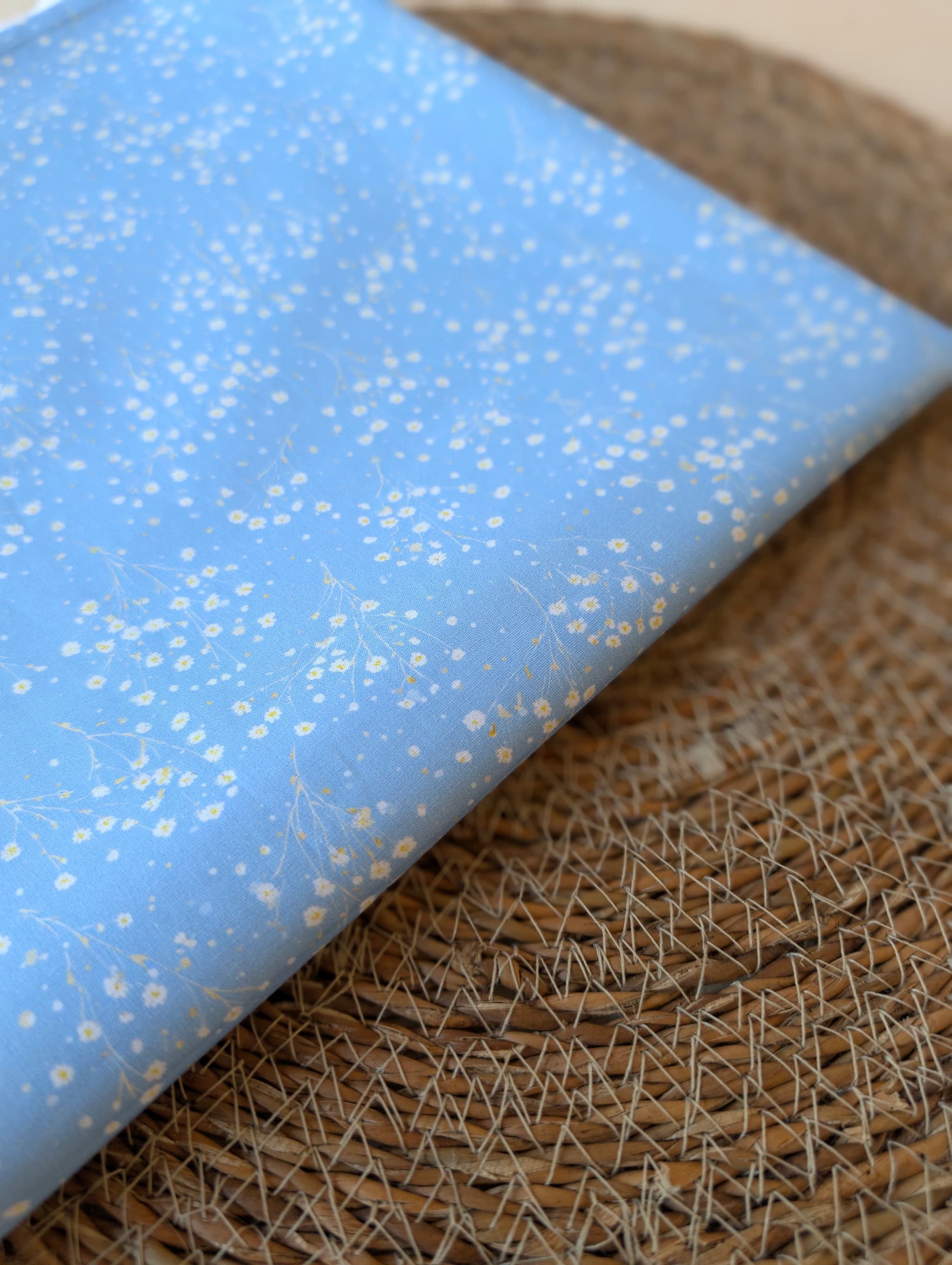 Clara Daisy Floral Cotton Poplin by esorai — scattered white daisy print on cornflower blue ground, fabric draped in wicker basket