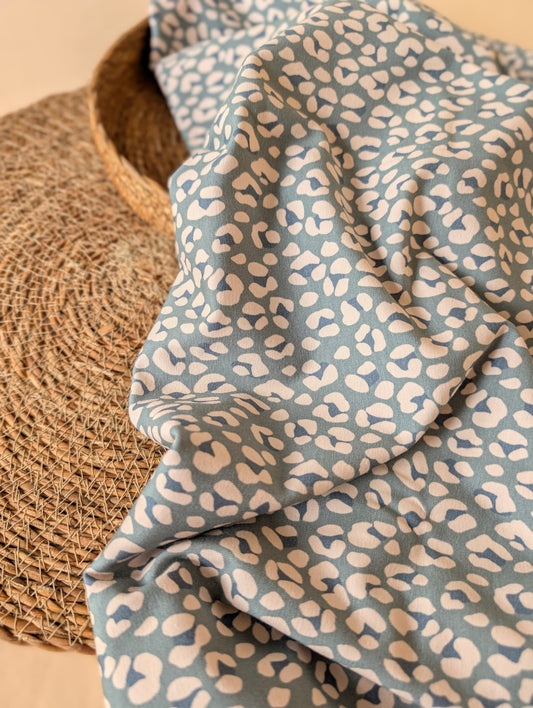 Cleo Leopard Cotton Jersey in Duck Egg folded flat on wicker mat — exclusive esorai leopard print in soft duck egg blue on cotton elastane jersey — Esorai
