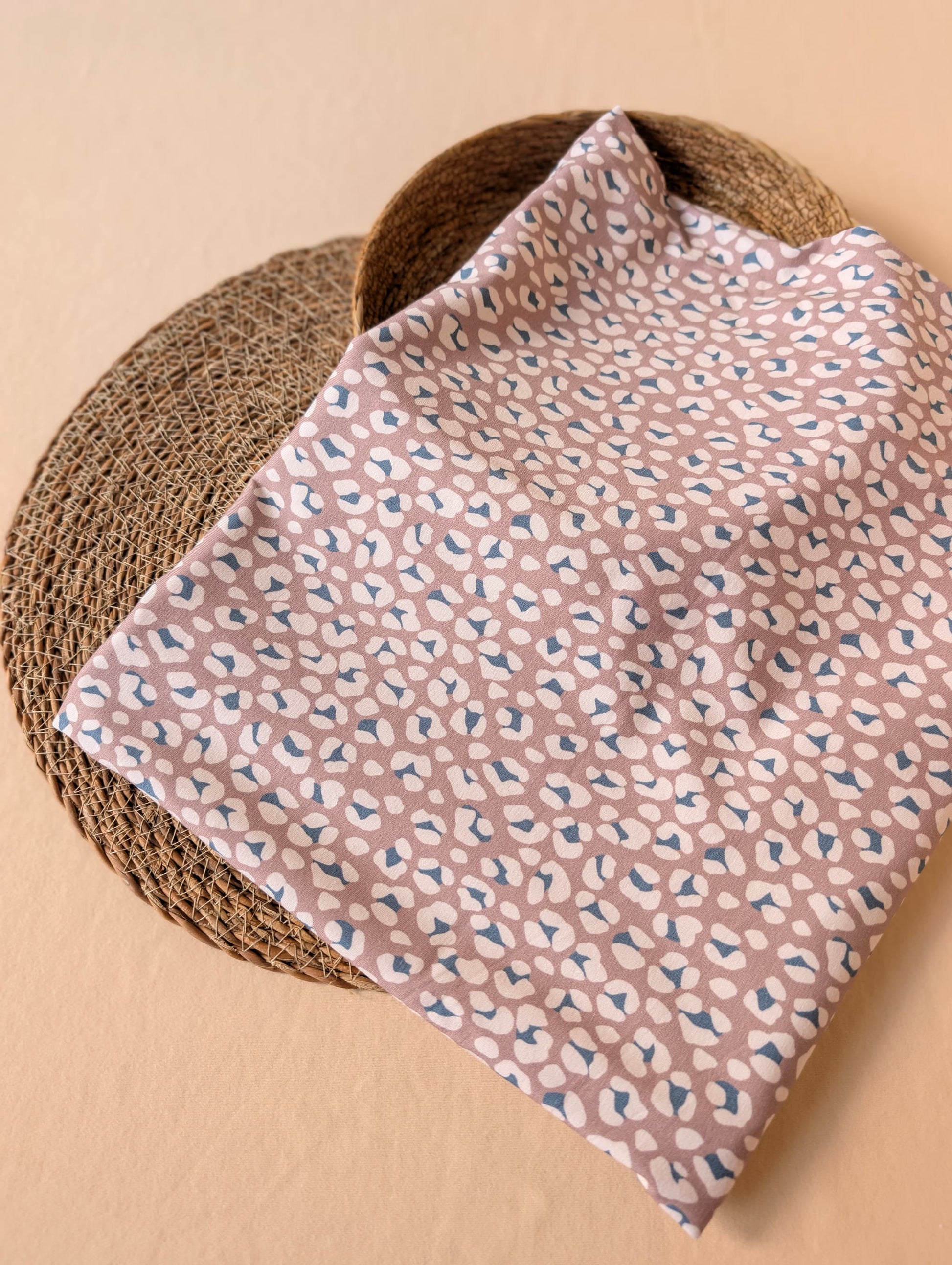Cleo Leopard Cotton Jersey in Mauve folded flat on wicker mat — exclusive esorai leopard print in soft dusty mauve on cotton elastane jersey — Esorai
