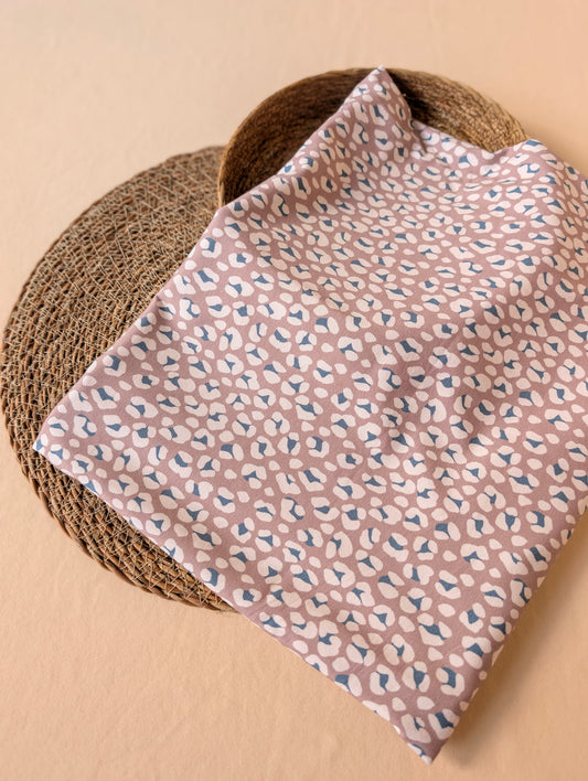 Cleo Leopard Cotton Jersey in Mauve folded flat on wicker mat — exclusive esorai leopard print in soft dusty mauve on cotton elastane jersey — Esorai