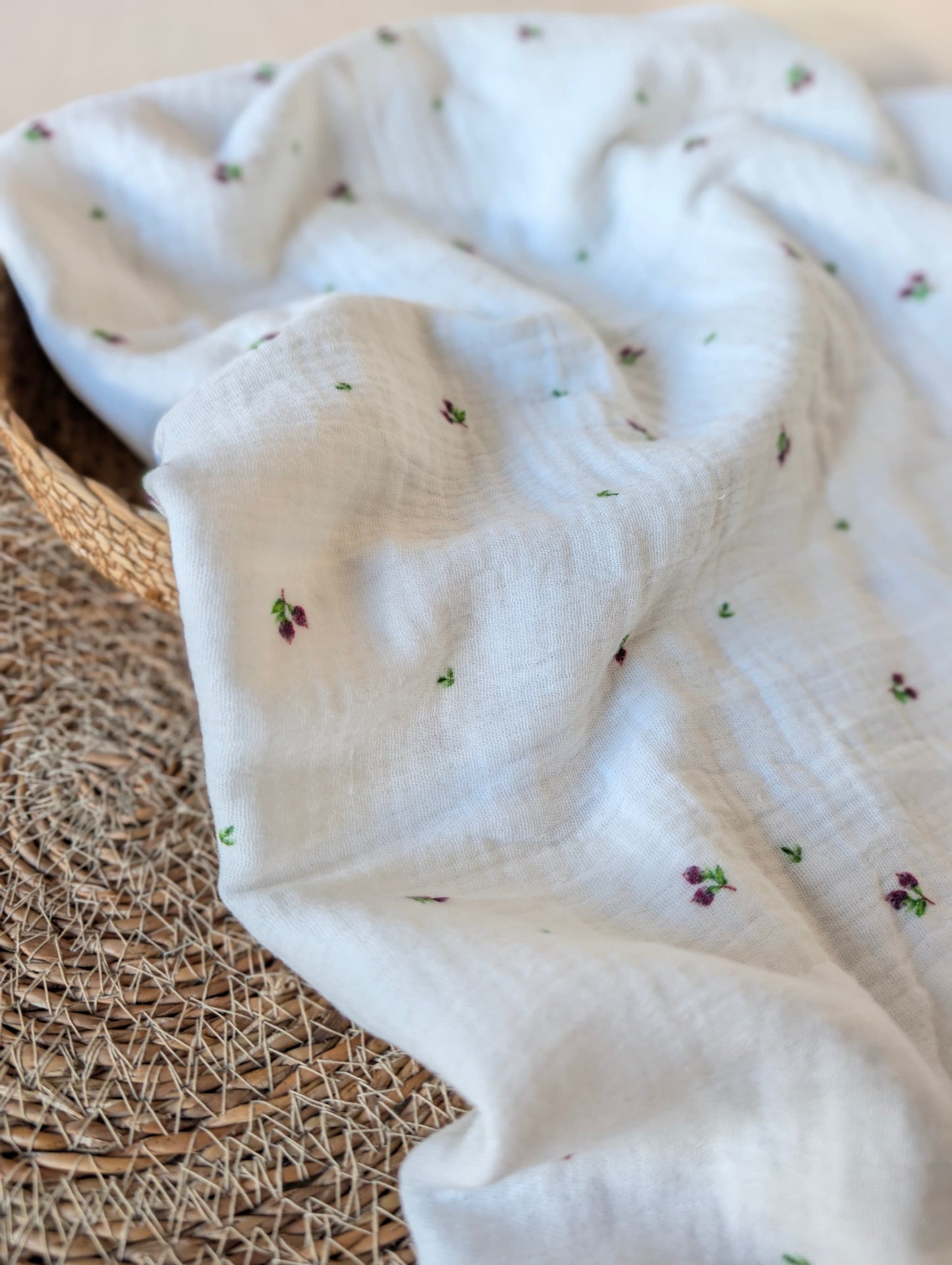 Double gauze fabric draped loosely in a rattan basket showing soft drape — Mini Blueberries, tiny plum berry clusters and green leaves on white