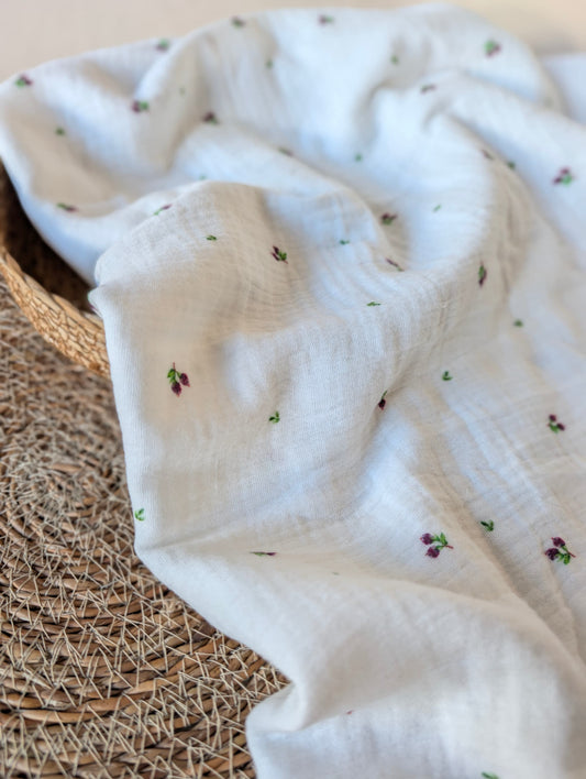 Double gauze fabric draped loosely in a rattan basket showing soft drape — Mini Blueberries, tiny plum berry clusters and green leaves on white