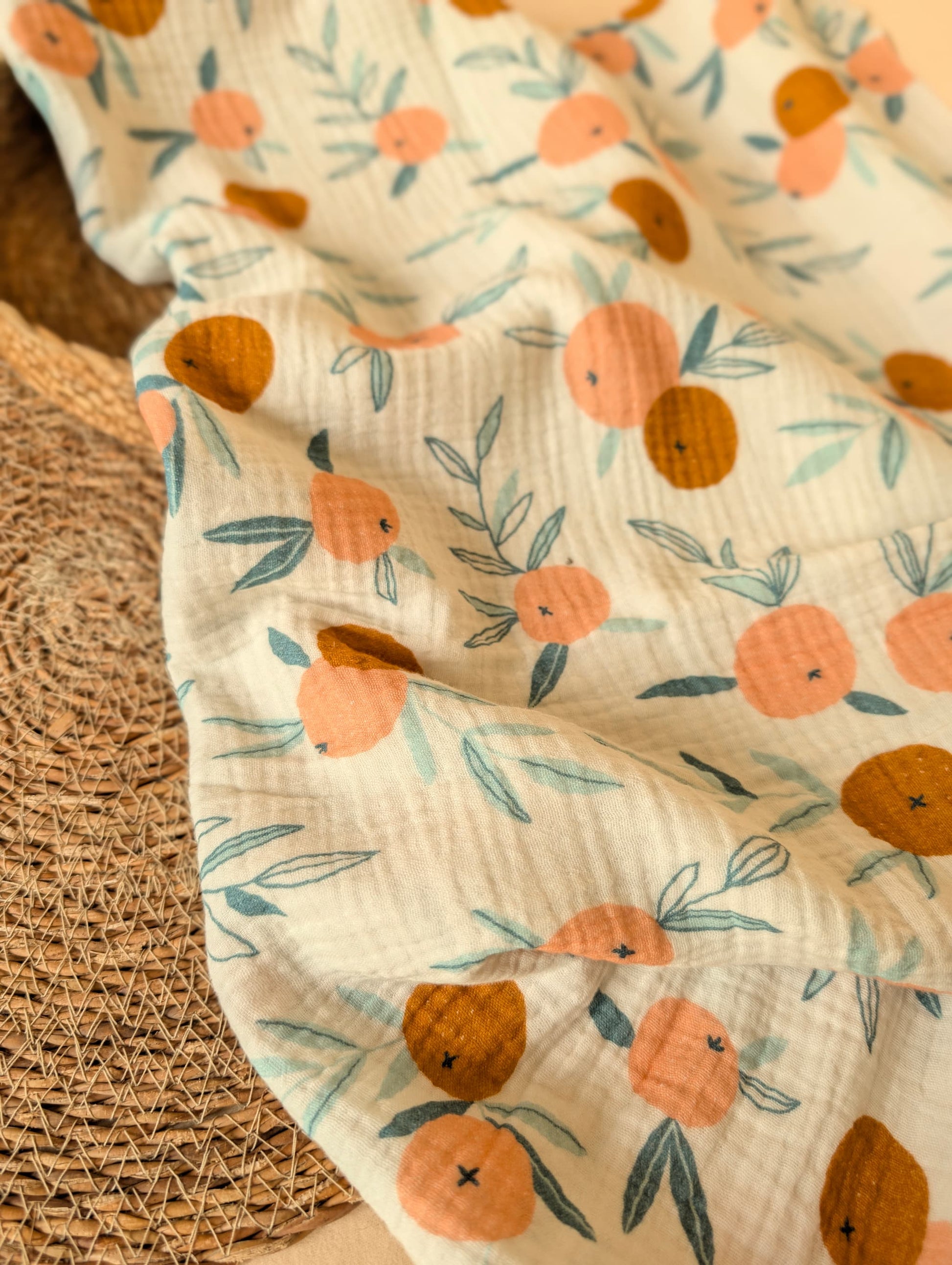 Floral-patterned fabric with orange and pink flowers on a textured surface