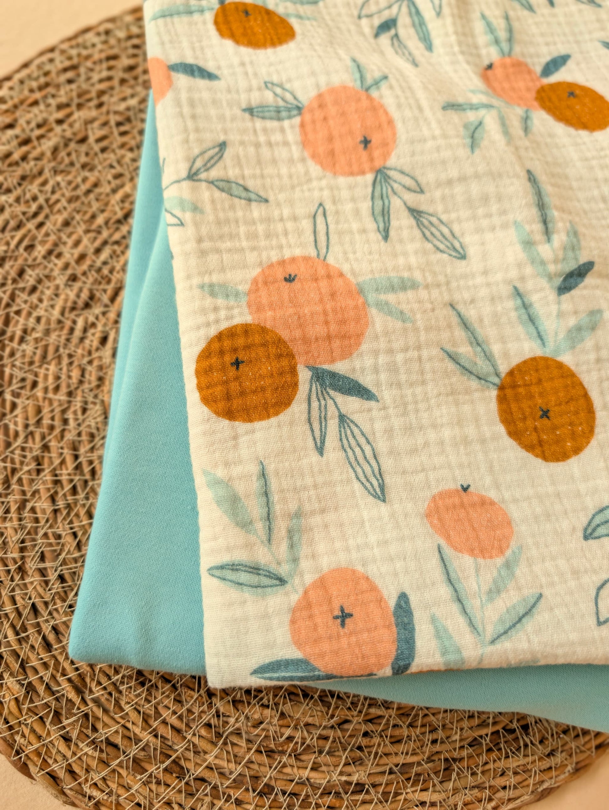 Fabric with orange and leaf pattern on a textured surface