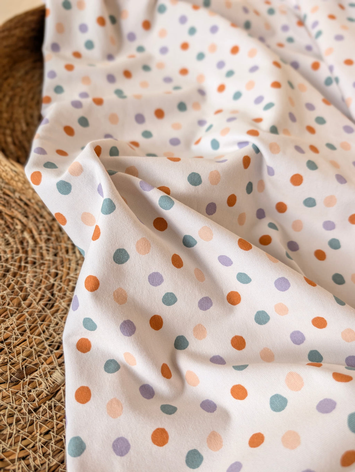 Cotton jersey fabric draped and gathered — Etta Spot in pastel multi, scattered spots in terracotta, teal, lilac and peach on white