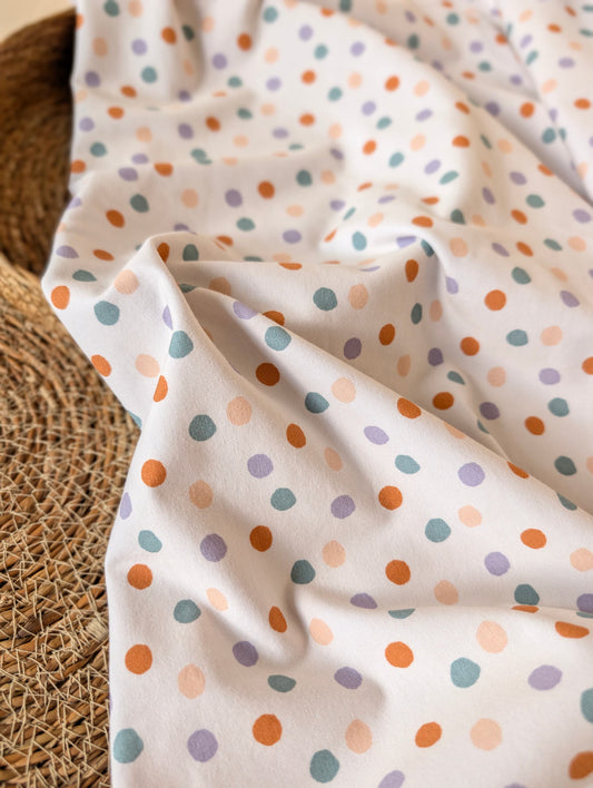 Cotton jersey fabric draped and gathered — Etta Spot in pastel multi, scattered spots in terracotta, teal, lilac and peach on white