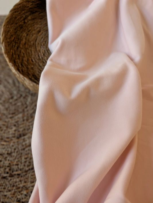 Pale blush pink premium-weight organic cotton jersey draped over a wicker basket — Cotton Jersey Plain in Blush by Esorai