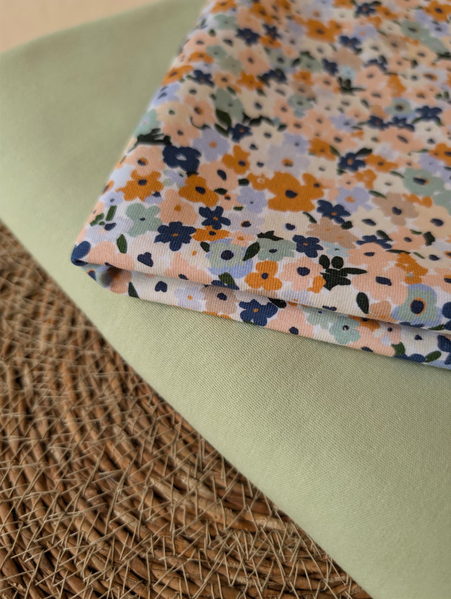 Soft mint green premium-weight organic cotton jersey draped over a wicker basket — Cotton Jersey Plain in Pistachio by Esorai