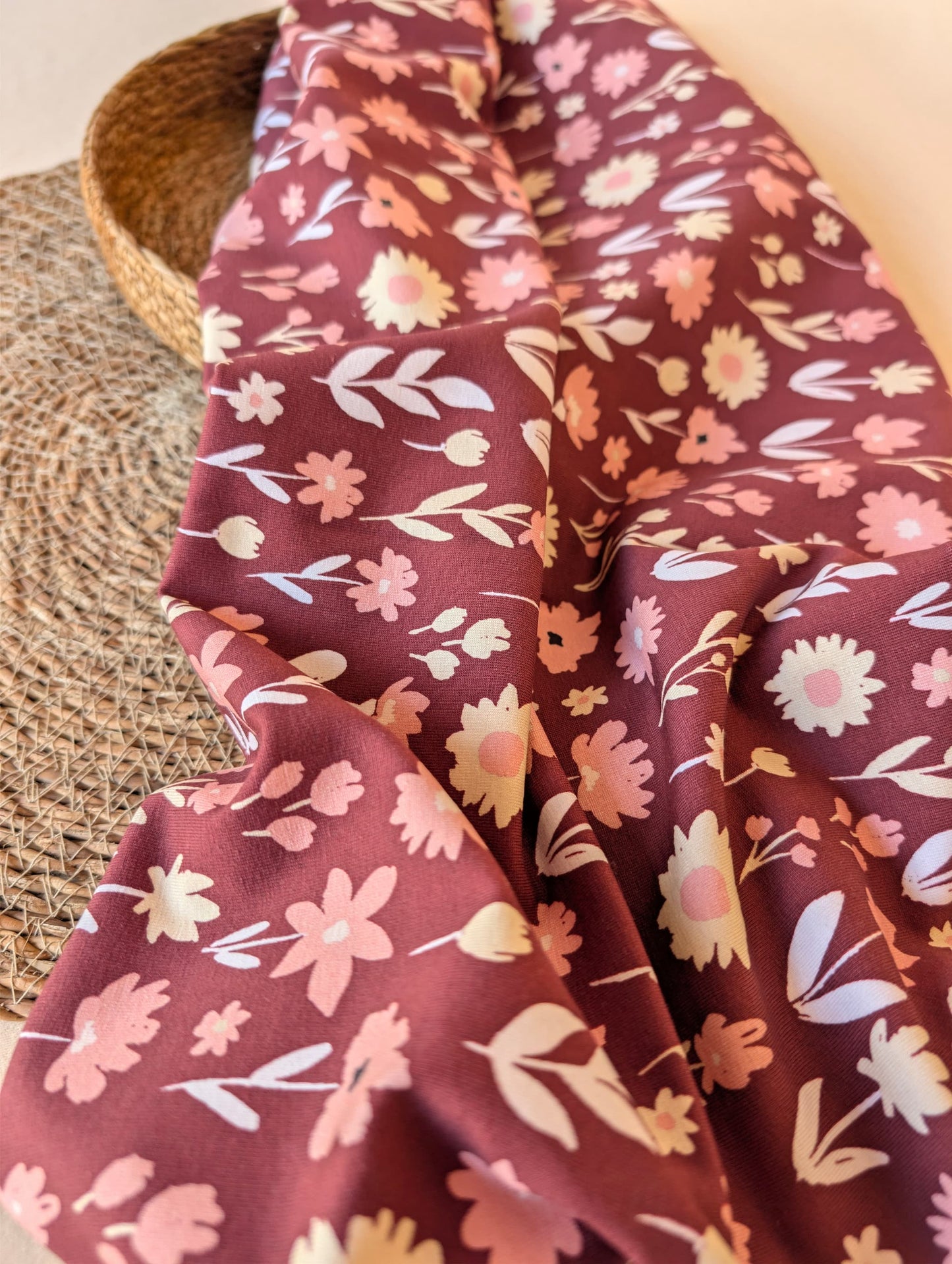 Ottie Floral cotton jersey in Burgundy showing the soft drape and scattered wildflower print — daisies and botanical sprigs in pink and cream — Esorai