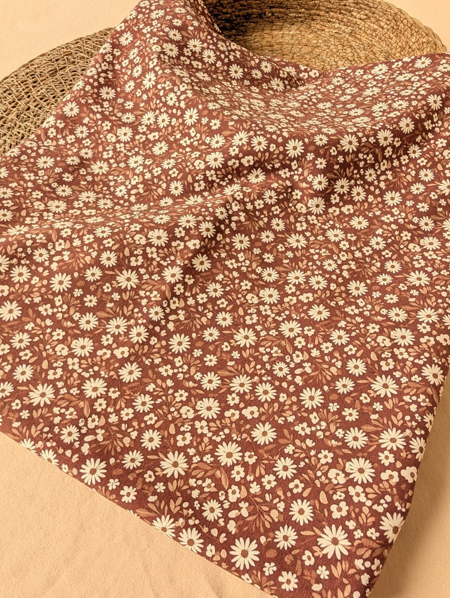 Willa Floral Cotton Jersey Rust — flat lay showing dense ditsy daisy and leaf print on warm brown cotton jersey